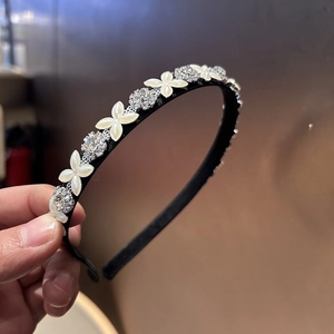 Nahaufnahme des Haarreifs mit weißen Kleeblatt-Muscheln und funkelnden Kristall-Strasssteinen