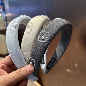 Detail of three handmade padded headbands with woven texture and pearl flower embellishments