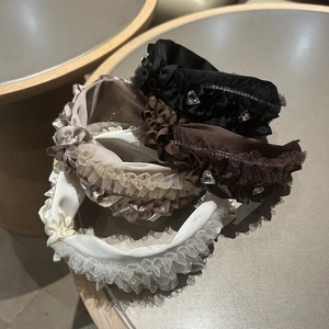 Detail von vier Seersucker-Haarbändern mit Spitzenrand und Herz-Strass in neutralen Farben