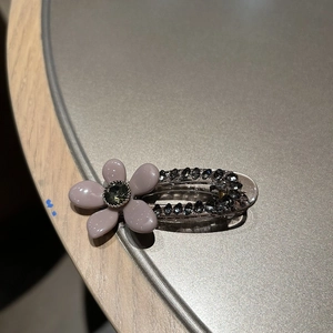 Détail macro d'une pince à cheveux vintage avec strass et fleur aux pétales lavande