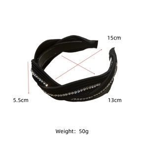 Detail view of wide black fabric headband with rhinestones and twist knot design