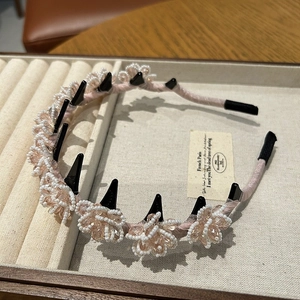 Detail of pink crystal flower headband with non-slip hair teeth on a beige tray