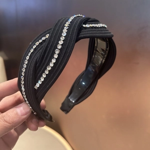 Detail of black twisted headband featuring ribbed fabric and sparkling rhinestone trim