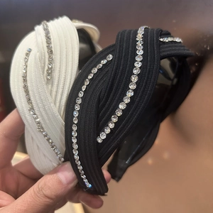 Detailed close-up of crisscross headband featuring ribbed knit fabric and rhinestones