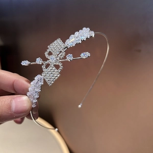 Détail d'un serre-tête argenté avec motif papillon en cristal et pierres scintillantes