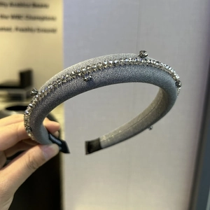 Close-up of a grey padded sponge headband with rhinestone chains and star crystals