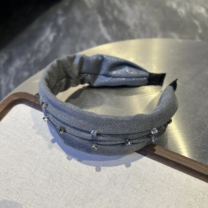 Detail of grey wide headband with shimmering fabric and delicate square crystals