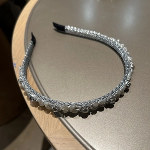 Detaillierte Nahaufnahme von glitzerndem Strass-Haarreif mit weißen Perlen und Silberbasis
