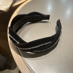 Close-up of black knot headband featuring two parallel rows of clear rhinestones decor