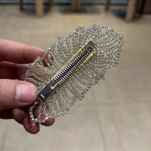 Detailansicht der gewebten Kristallperlen und goldene Bandwicklung am Haarclip