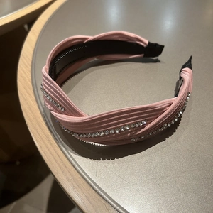 Close-up of pink woven headband with sparkling rhinestones and anti-slip teeth lining