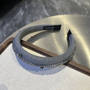 Close-up of handmade grey beaded headband with sparkling crystals and fabric texture