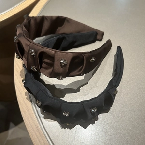 Detail of satin padded headbands in black and brown featuring sparkling rhinestone accents