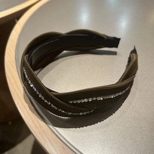 Detail of olive green luxury fabric headband with sparkling rhinestones and twisted design