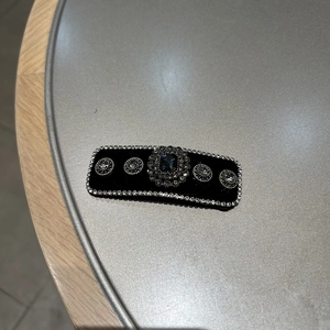 Detail of vintage velvet hair clip with blue gemstone and rhinestone edges
