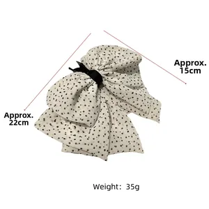 Detailed size view of polka dot mesh bow hair clip measuring approx. 22cm x 15cm