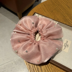 Close-up of pink layered organza scrunchie with embedded pearls and sparkling rhinestones