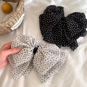 Detailed view of large polka dot mesh bow hair clips in black and white chiffon fabric