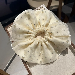 Détail d'un chouchou géant en résille à pois avec accents de perles élégantes