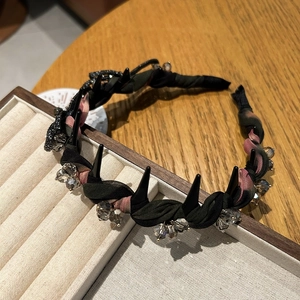 Détail du serre-tête plissé noir avec pointes punk et décoration de perles de cristal gris