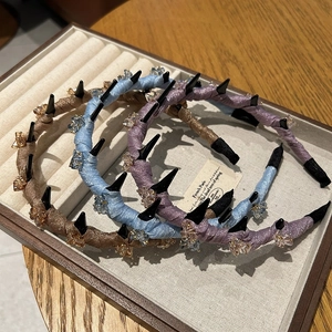 Mesh-wrapped hairbands with decorative spikes and crystals in brown, blue, and purple tones