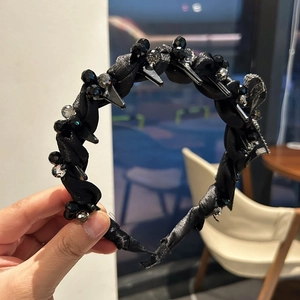 Detail of black woven headband with crystal beads and integrated small hair clips for styling