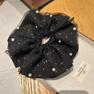 Détail de chouchou en tulle noir à pois blancs, perles d'imitation et paillettes
