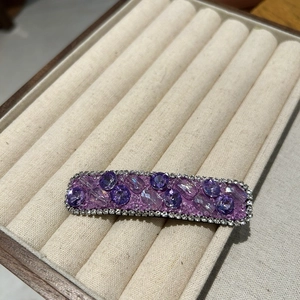 Detailed view of luxury purple crystal hair clip with shimmering rhinestones and beads