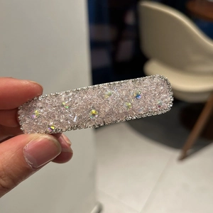 Handheld view of a luxury rectangular hair clip with pink crystals and AB rhinestones
