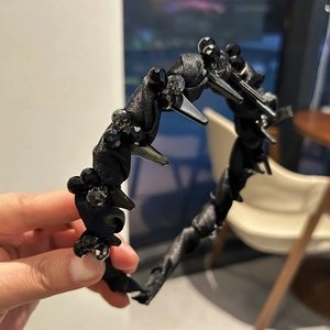 Detailed view of punk style black headband with metallic spikes and faceted beads