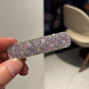 Detailed close-up of a luxury square hair clip with pink and AB crystals in hand