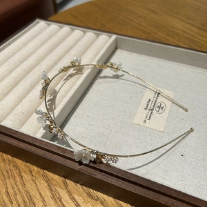 Elegante diadema de metal dorado con flores blancas, perlas y cristales brillantes