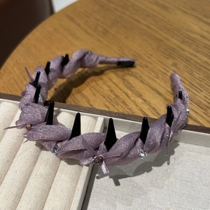 Detailed view of purple twisted mesh headband featuring black studs and sparkling rhinestones