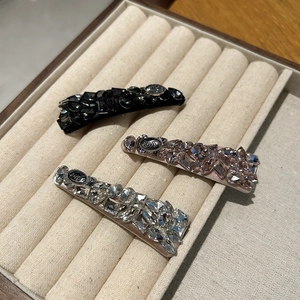 Close-up of sparkling rhinestone hair clips set with vintage Love engraved metal plates