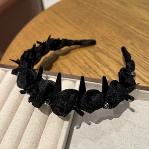 Detail view of black mesh twist headband with punk spikes, silk bow and crystals