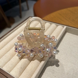 Dettaglio della molletta per capelli in resina champagne con cristalli e perle