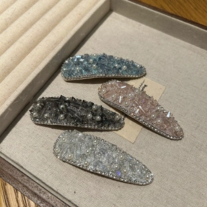 Detailed close-up of sparkling rhinestone hair clips with faux pearls and crystals