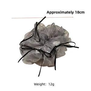 Detail of silver-grey tulle scrunchie with black ribbon bow measuring approx 18cm