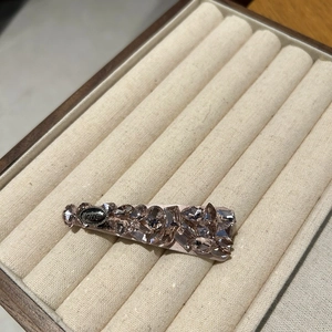 Close-up of sparkling rhinestone hair clip with vintage love engraved metal plaque