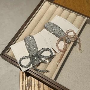 Close-up of handmade flower hair clips with crystals and pearls on display card