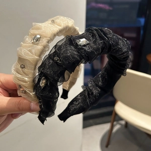 Détail de serre-têtes plissés faits main en beige et noir avec cristaux de luxe