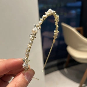 Vue détaillée du serre-tête floral doré orné de perles blanches et cristaux