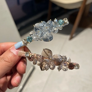Detail of floral crystal duckbill hair clips in sky blue and champagne colors
