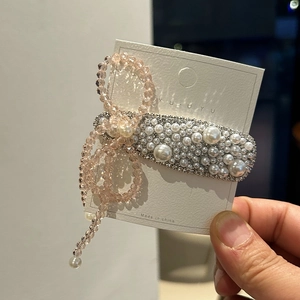 Elegant pink crystal bow hair clip with white pearls and sparkling side rhinestones