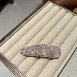 Macro detail of luxury hair clip with pink crystals, white pearls and sparkling rhinestones
