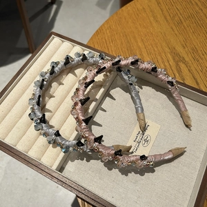 Detailed view of luxury crystal headbands with pink and blue fabric and punk studs