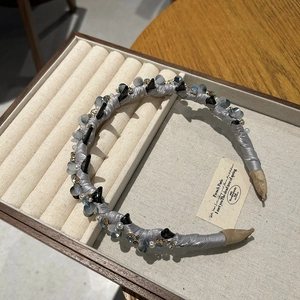 Luxury gray satin headband with crystal beads and rhinestones on jewelry display