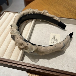 Détail du serre-tête en résille plissée beige avec strass étincelants et dents antidérapantes