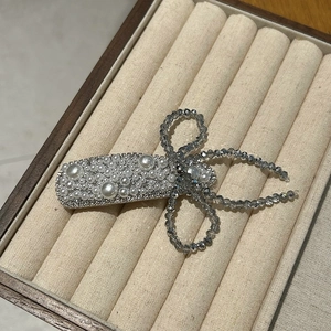 Detailed macro of vintage crystal pearl flower hair clip resting in a velvet jewelry box