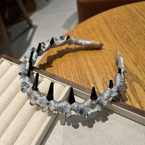 Detail of luxury crystal headband with silver satin, black spikes and faux pearls